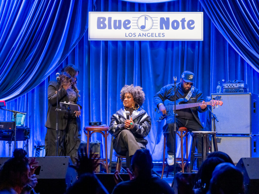 Rapsody and her band on stage beneath the Blue Note Los Angeles sign