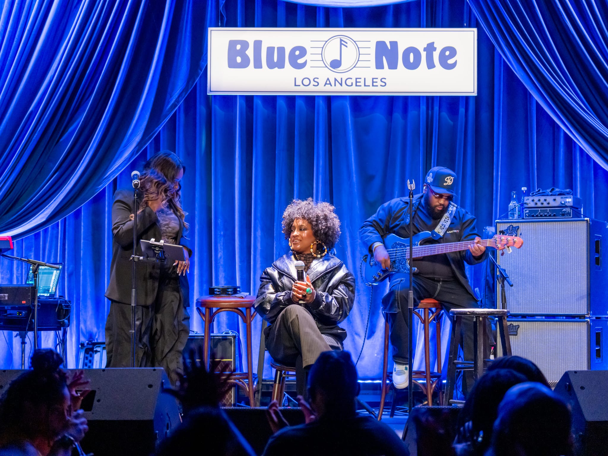 Rapsody and her band on stage beneath the Blue Note Los Angeles sign